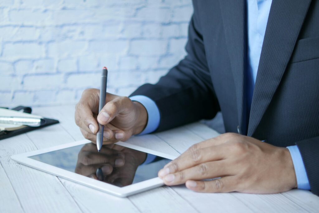 Man in suit using stylus on tablet for business work indoors